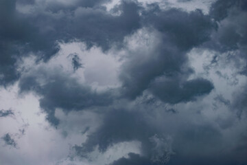 Dark storm clouds and gray gloomy clouds, a terrible natural phenomenon, rain from afar, view from the side