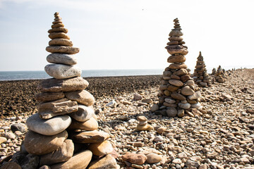 Fototapeta na wymiar Cairns made from pebbles on the beach