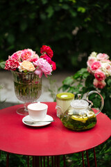 Obraz na płótnie Canvas Morning summer tea set in the garden on red table