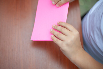 Children are involved in folding paper.
