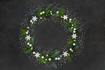 Christmas & solstice wreath with star & silver ball decorations, mistletoe & cedar cypress fir on...