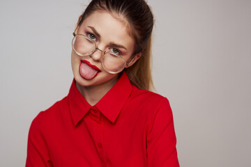 fashionable woman in a red shirt on a light background fun emotions bright makeup glasses attractive appearance 