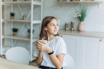 Close up portrait of young cute adorable caucasian girl in cozy kitchen