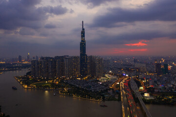 Obraz premium Aerial urban colorful sunrise panorama with high rise building disappearing into the clouds, city center skyline and suburban sprawl