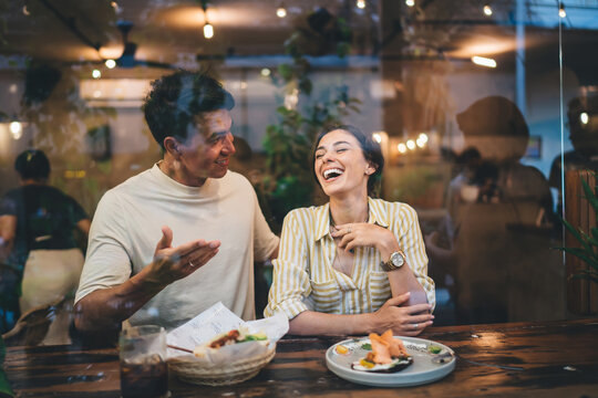 Cheerful diverse people having lunch in cafe