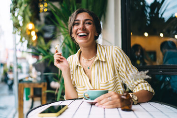 Happy woman having coffee break in outdoor cafe