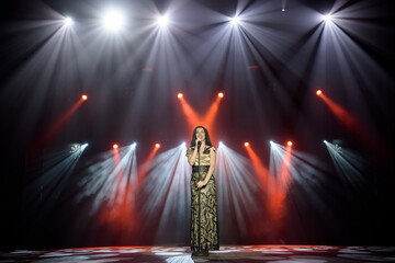 Young woman with microphone in hand on entertainment event.