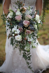 Wedding Photography Bride Holding Cascading Bridal Bouquet with Pink, Mauve, Purple, and White Roses