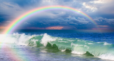 Beautiful landscape with turquoise sea with double sided rainbow at sunset