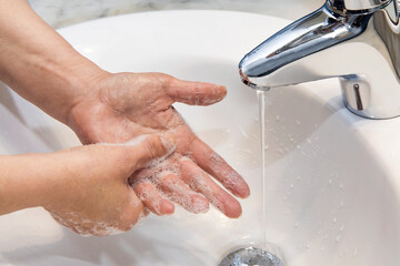 Washing hands at bathroom with soap, preventing coronavirus COVID-19 disease 