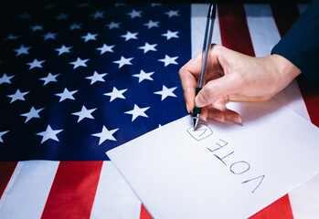 American flag. Elections in the USA. Woman putting tick on the paper for vote. Political changes in...