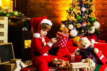 Holidays and winter childhood concept. Little boy with Christmas presents. Christmas time. Little...