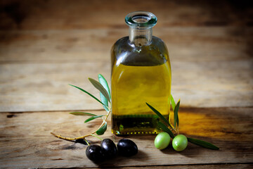 Olive oil and olive branch on the wooden table