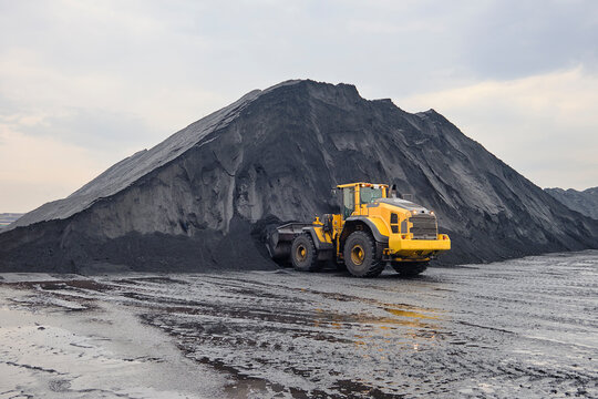 Iron ore stockpile at cargo terminal storage sites during cargo operation using wheel loader
