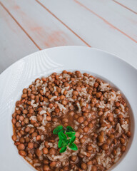 bowl of lentils with rice on white wooden background