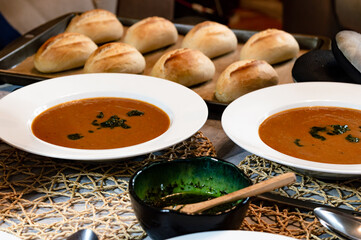 Homemade tomato soup served with bread rolls