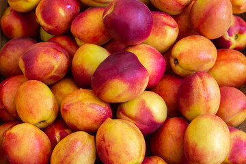 Bright nectarines in the market. Nectarines closeup background. Image with selective focus