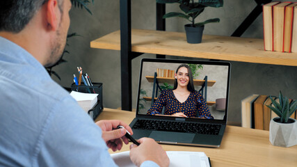 Fototapeta na wymiar Businessman at home office communicates talk speak with top manager company online by conference video call laptop. Smiling beautiful woman employee in computer screen listens man CEO by remote webcam