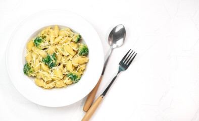 pasta with broccoli in creamy sauce in white plate