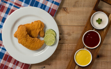 breaded chicken filet, on a wooden background. top wiew.