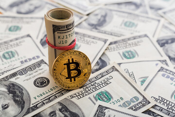 Fototapeta premium Golden Bitcoin coin on a us dollars close up.