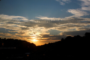 Sunset with clouds and silhouette trees orange sunset
