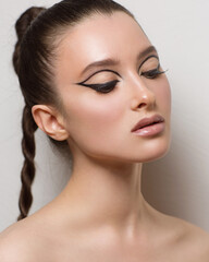 Beauty portrait with creative makeup on a white background in the studio. Close-up portrait with graphic arrows