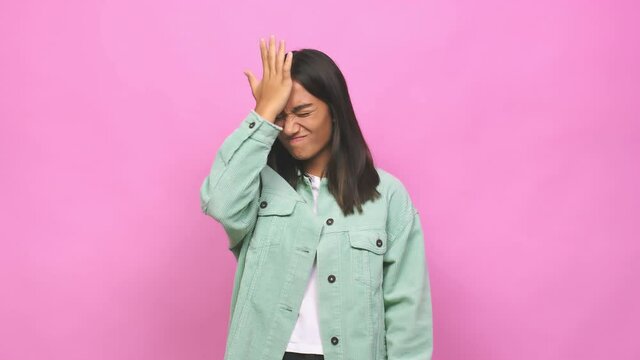 Young mixed race indian woman forgetting something, slapping forehead with palm and closing eyes