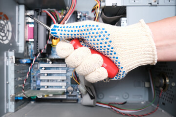 A hand of a technician repairer holding a screwdriver in order to upgrade or repair a broken home...