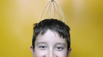 A caucasian boy enjoy head scalp massage by anti stress acupuncture metal octopus tool, equipment,...