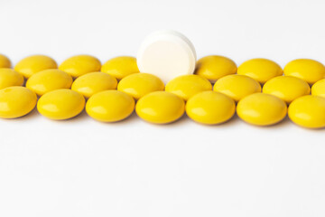 The tablets are yellow and one white tablet in the center. Direct view.