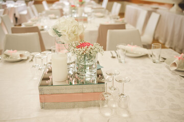 Pastel pink-white elegant wedding decoration with flowers, mirror, decorated table for celebration.