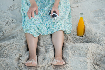 Women with sunglasses and orange juice on the beach