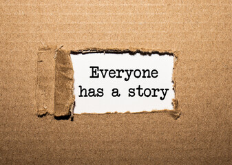 The text everyone has a story. behind torn brown paper