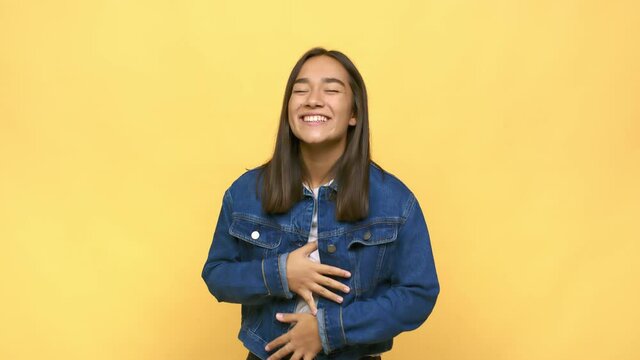 Young mixed race indian woman laughs happily and has fun keeping hands on stomach