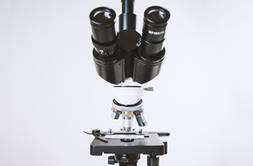 Using a biological microscope. Close up of a microscope. Scientific research concept, using a microscope. Medical examinations, searching for bacteria, diseases, blood tests.