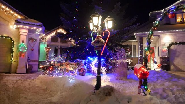 Displays on snow covered front yards of houses at Christmas