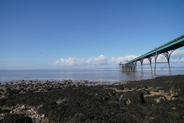 Fototapeta na wymiar Panoramic photo of Clevedon Pier in somerset showing iron structure against blue sky