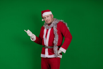 Male actor in a costume of Santa Claus gesturing and posing on a green chroma background