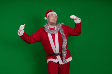 Male actor in a costume of Santa Claus gesturing and posing on a green chroma background