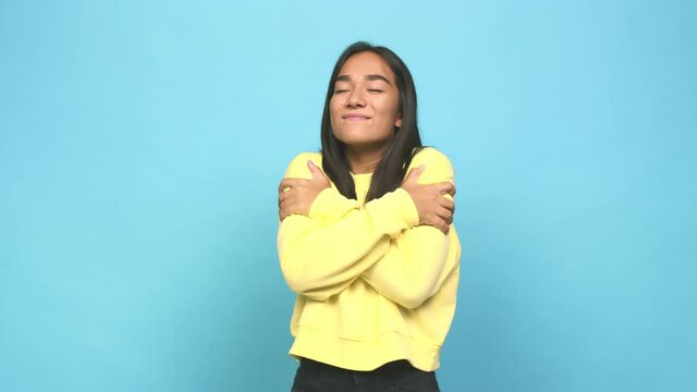 Young mixed race indian woman hugs, smiling carefree and happy