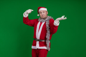 Male actor in a costume of Santa Claus gesturing and posing on a green chroma background
