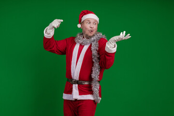Male actor in a costume of Santa Claus gesturing and posing on a green chroma background