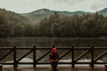 Naklejka premium The Man Standing on Wooden Pier in Forest