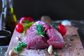 raw beef meat on cutting board on black marble background. close up view