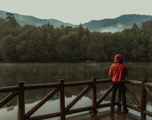 Fototapeta premium The Man Standing on Wooden Pier in Forest