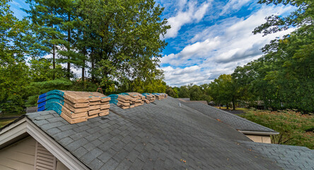 Shingle Bundles Stacked on Roof to Repair Storm Weather Damage