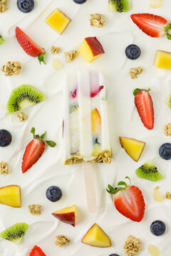 Yogurt parfait ice lolly on greek yogurt and fruit background