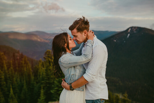 Couple embrace on top of mountain