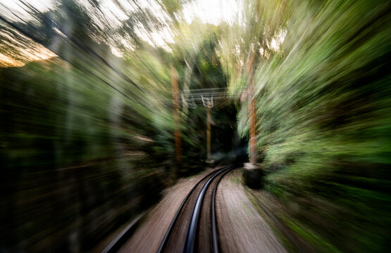 Sun flare peaks out on the tracks of a railroad